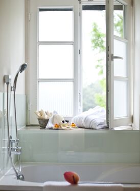 Badewanne mit Brause am Fenster